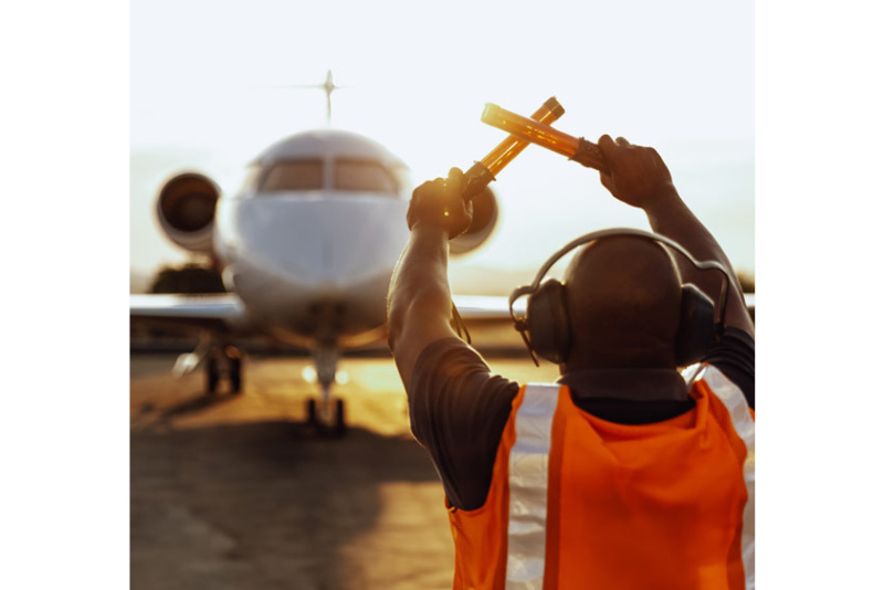 Airport worker directing a jet